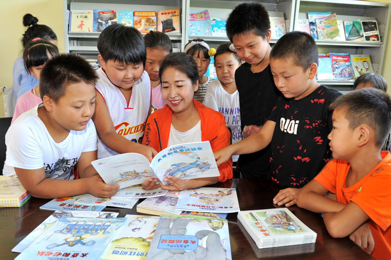 在暑假的公益課堂活動中，王嬌給村里的孩子講故事