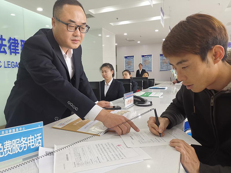 中心法援窗口工作人員指導(dǎo)市民填寫法援申請(qǐng)表