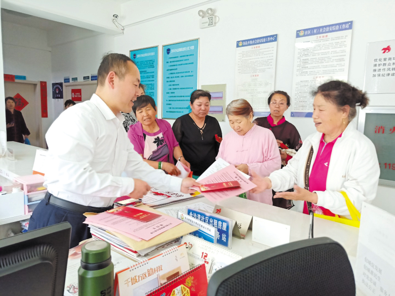 配文1：社區(qū)工作者向居民發(fā)放普法宣傳冊(cè)