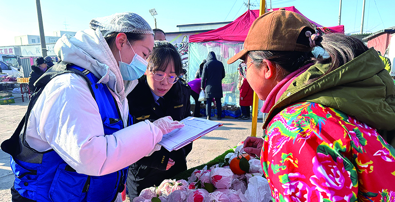 市場(chǎng)監(jiān)管工作人員和抽檢人員一起為抽檢樣品做登記