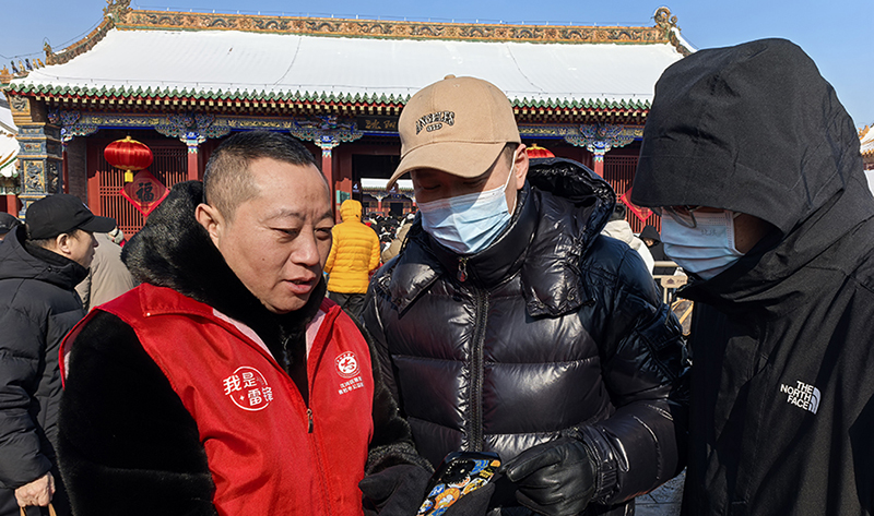 沈陽(yáng)市善若水公益服務(wù)中心理事長(zhǎng)高聰(左)為游客指路