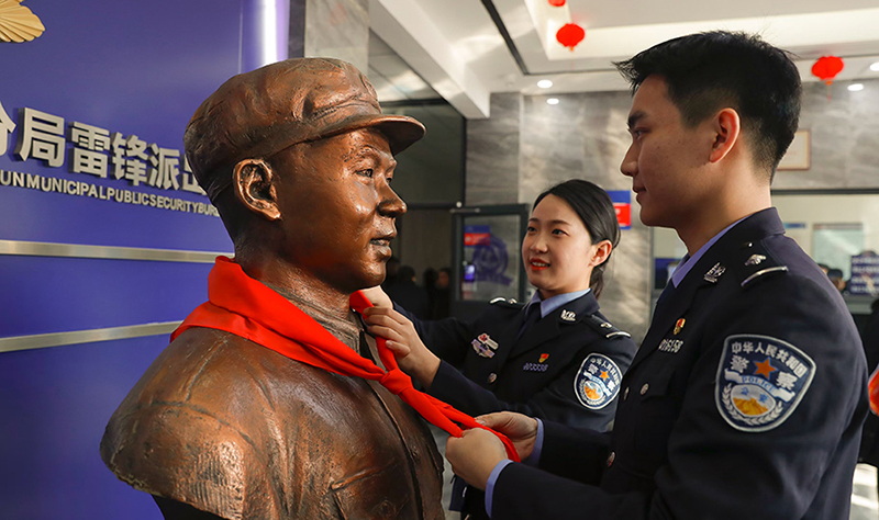2024年3月5日，撫順市公安局望花分局雷鋒派出所民警白靜（右）和長(zhǎng)沙市公安局雷鋒派出所民警韓政霖（左）共同為雷鋒塑像整理紅領(lǐng)巾。