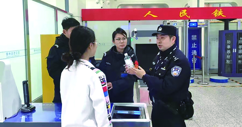 二題圖，童秋華（右）在向旅客講解安檢規(guī)定