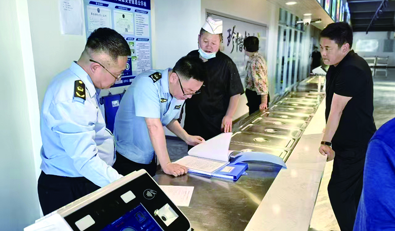 執(zhí)法人員在學(xué)校食堂后廚檢查食材進(jìn)貨渠道