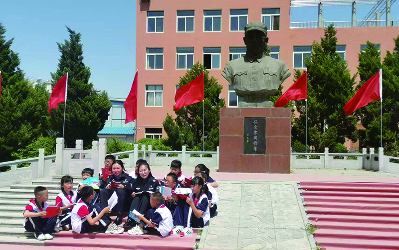 頭題圖，普法志愿者在愛國主義教育基地為學生們普法。