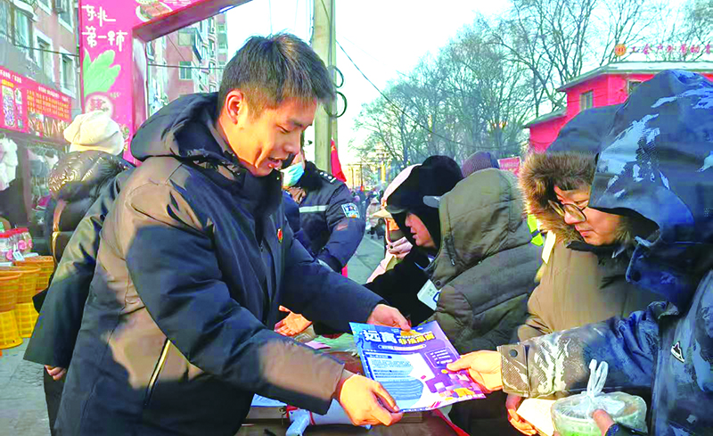 工作人員在早市上講解反詐常識(shí)