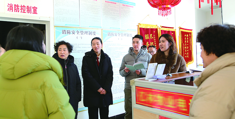 記者跟隨趙洋（左三）法官走訪，在物業(yè)服務(wù)中心向業(yè)主了解近況