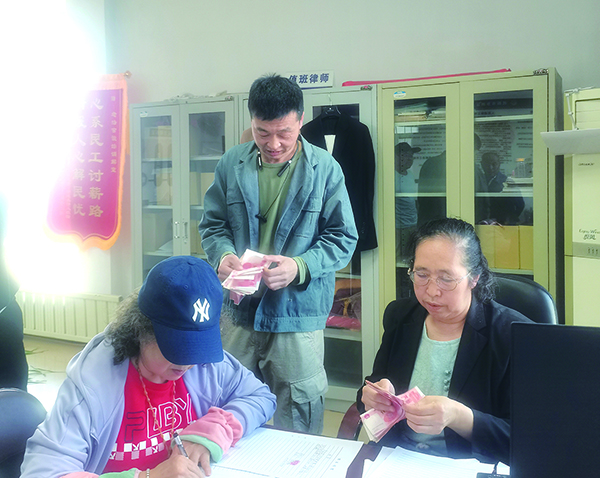 發(fā)放現(xiàn)場，付菊（右一）逐筆核對勞務(wù)費（受訪單位供圖）